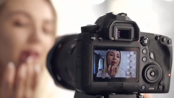 Een make-up artiest wordt gefilmd en getoond op een camera display — Stockvideo