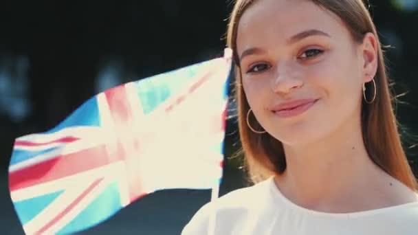Европейский студент размахивает флагом Великобритании — стоковое видео