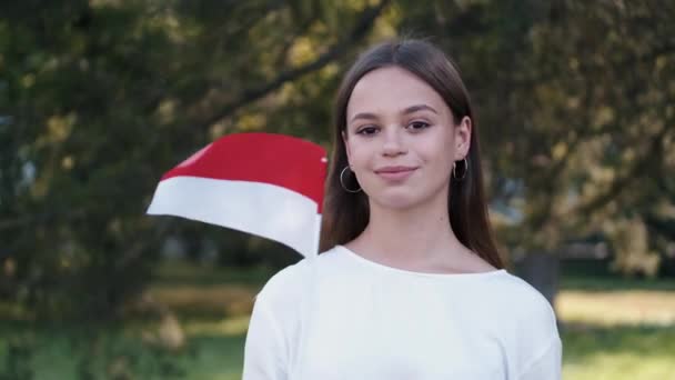 De student zwaait met de vlag van Polen op een stok — Stockvideo