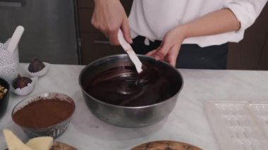 Avrupalı bir kadın sıcak çikolatayı kasede karıştırıyor.
