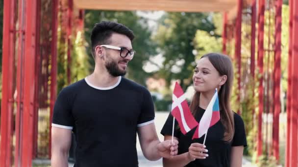 Два европейских студента размахивают флагами стран — стоковое видео