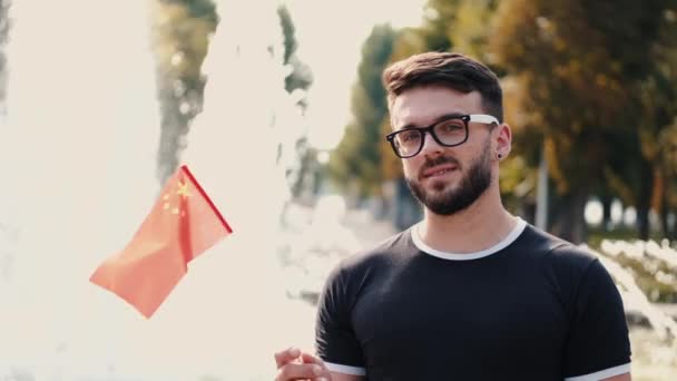 The young man is showing the national flag of China on a stick — Stock Video