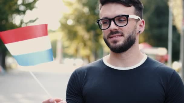 Un estudiante muestra la bandera nacional de los Países Bajos — Vídeo de stock