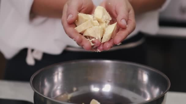 De vrouw gooit witte chocoladestukjes in een kom — Stockvideo