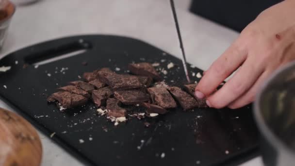 La femme divise la barre de chocolat noir en morceaux — Video