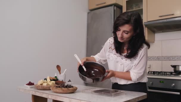 De huisvrouw schenkt warme chocolademelk in een kookvorm — Stockvideo