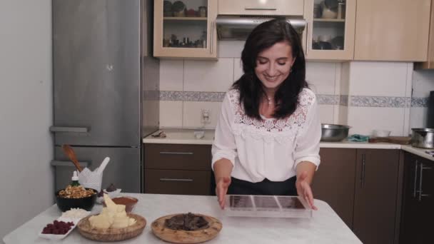 Dona de casa europeia está segurando barras de chocolate em uma forma de cozinha — Vídeo de Stock