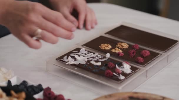 Gospodyni domowa ozdabia czekoladę jagodami i orzechami włoskimi — Wideo stockowe