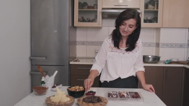 家庭主妇正在用浆果和核桃装饰巧克力 — 图库视频影像