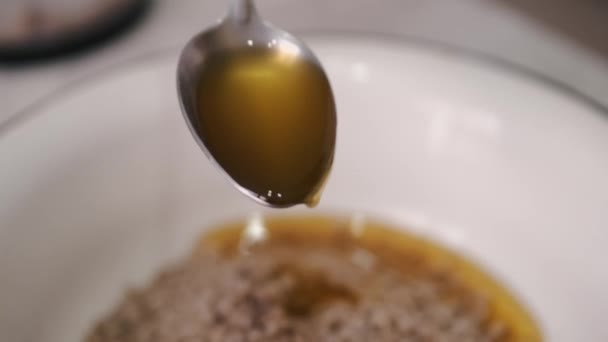 Kocken tillsätter en sked olja till massan. — Stockvideo