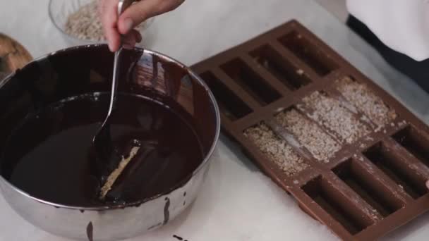 Ένας ζαχαροπλάστης βουτάει ένα γλυκό στη λιωμένη σοκολάτα. — Αρχείο Βίντεο