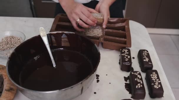 Кондитер окунает сладкое в расплавленный шоколад — стоковое видео