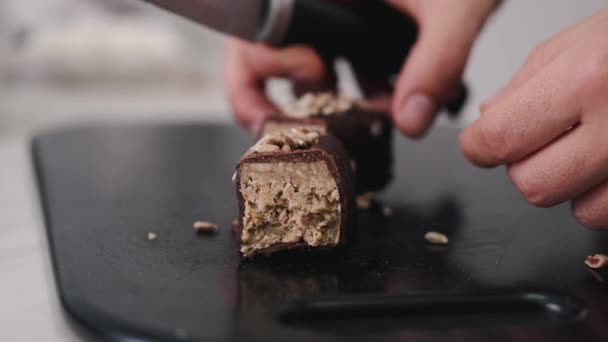 De banketbakker snijdt een chocolade zoet met zaden — Stockvideo