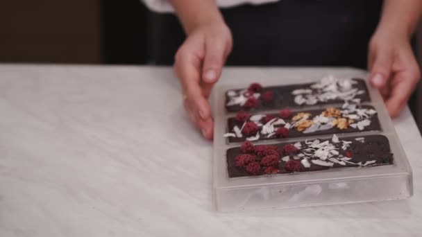 Домогосподарка бере заморожені шоколадні батончики з форми — стокове відео
