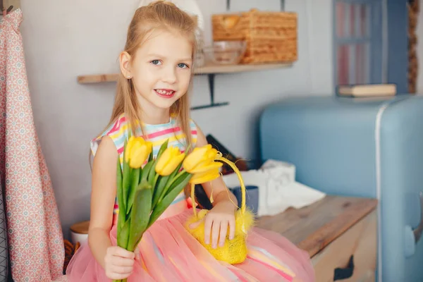 Niedliches kleines Mädchen mit gelben Blumen — Stockfoto
