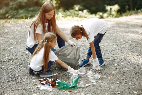 Дети собирают мусор в мешках для мусора в парке — стоковое фото