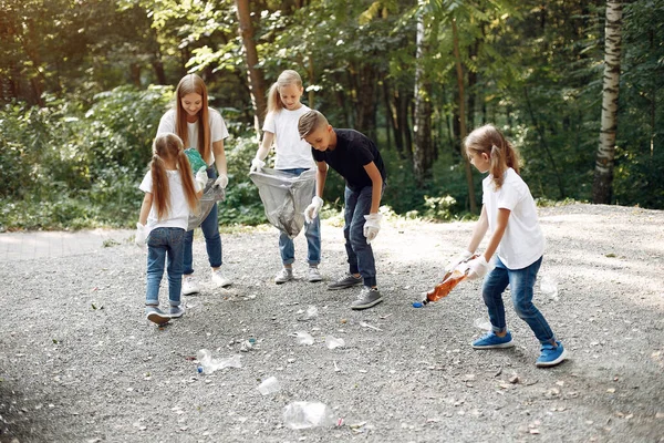 Children collects garbage in garbage bags in park — Stock Photo, Image