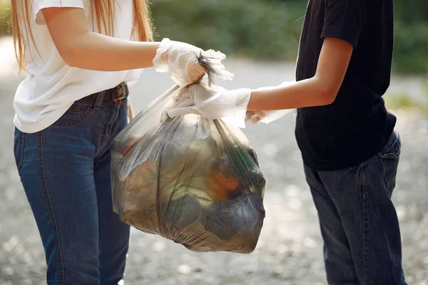 Дети собирают мусор в мешках для мусора в парке — стоковое фото