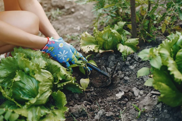 Beautiful woman works in a garden near the house — Stock Photo, Image