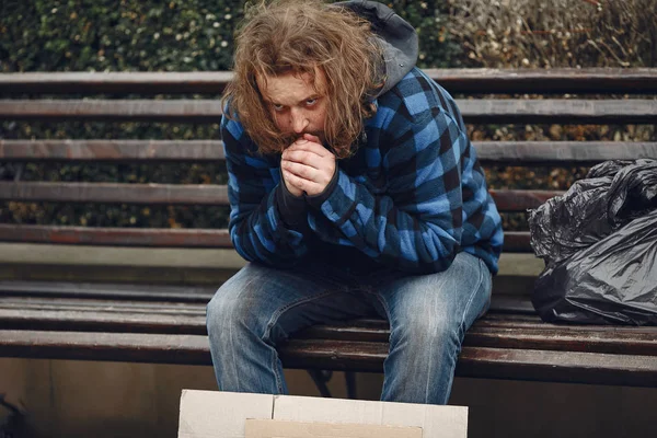 Бездомный в долгой одежде осенний город — стоковое фото