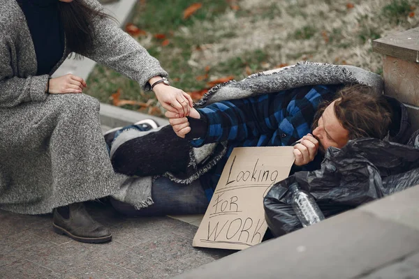 Hajléktalan férfi egy divatos ruhában ősz város — Stock Fotó
