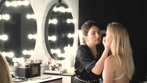 Maquiagem artista fazendo maquiagem para o cliente com cabelo loiro — Vídeo de Stock