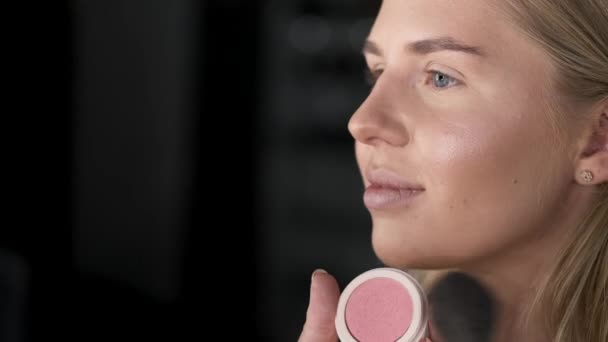 Крупним планом жіноче обличчя під час макіяжу в салоні — стокове відео
