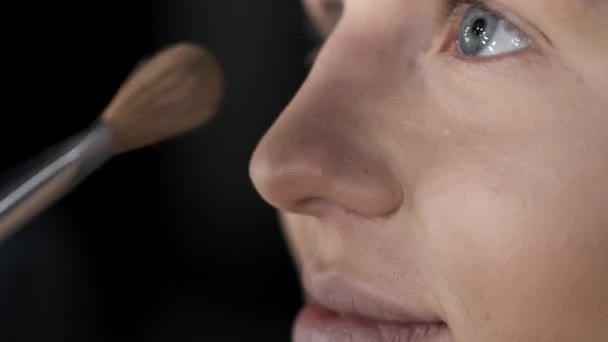 Primer plano de la cara femenina mientras se hace el maquillaje en el salón — Vídeo de stock