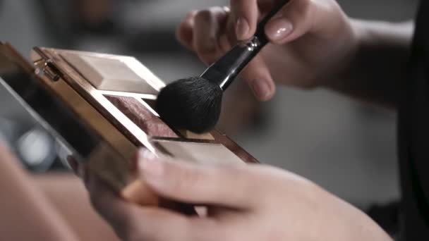 Szoros kozmetikumok és női kéz ecsettel szépségszalonban — Stock videók