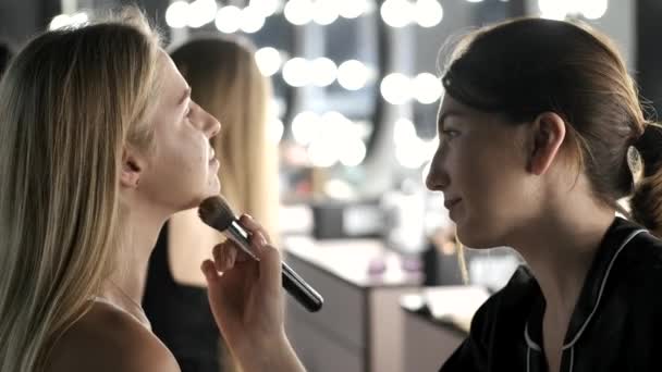 Kunstenaar en klant in een proces van make-up in schoonheidssalon — Stockvideo