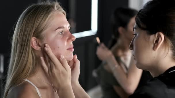 Maquiagem artista em uniforme preto com o cliente no salão de beleza — Vídeo de Stock