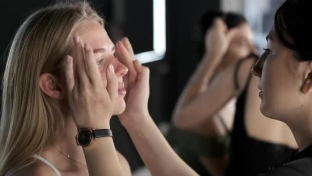 Maquillaje artista en uniforme negro con el cliente en salón de belleza — Vídeos de Stock