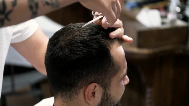 Fechar-se de barbeiros mãos que cortam o cabelo de clientes na barbearia — Vídeo de Stock