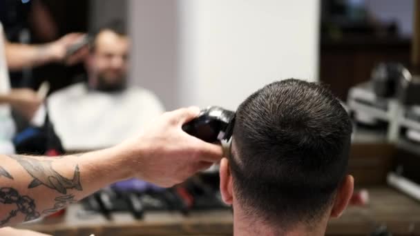 Cortar el cabello de los clientes con clipper negro en la peluquería — Vídeo de stock