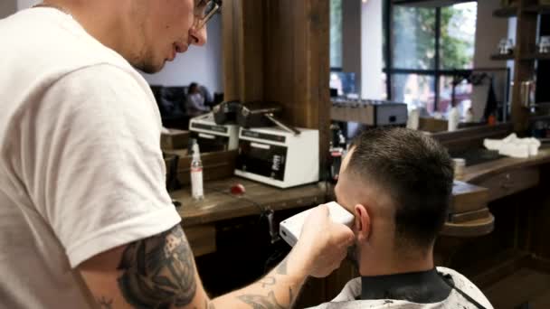 Peluquero haciendo peinado elegante para el cliente en la peluquería — Vídeos de Stock