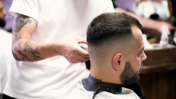 Stylista cięcia włosów klientów za pomocą Clipper w salonie — Wideo stockowe