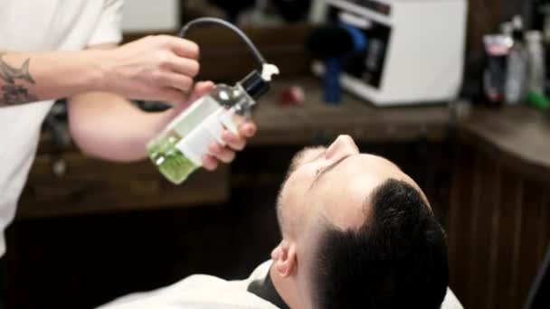 Peluquero verter líquido verde en la cara de los clientes en el salón — Vídeo de stock