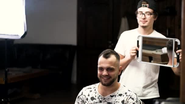 Peluquero mostrando corte de pelo al cliente en el espejo en la barbería — Vídeos de Stock
