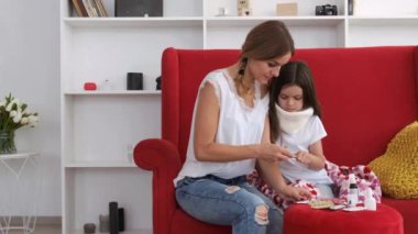 Annem hasta kızına oturma odasında ilaç veriyor.