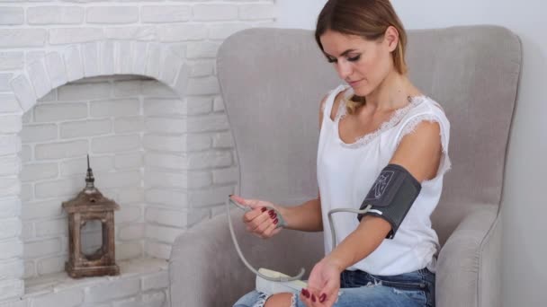Žena měření tlaku se stetoskopem v obývacím pokoji