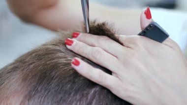Güzellik salonunda saç kesme işlemine makas ile yaklaşma