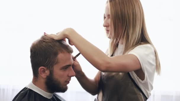 Estilista feminina fazendo corte de cabelo para o cliente no salão de beleza — Vídeo de Stock