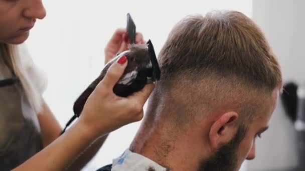 理发店里的理发师用机器剪短顾客的头发 — 图库视频影像