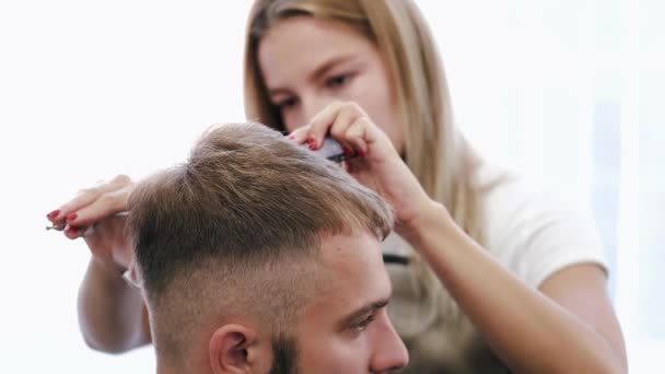 Coiffeur faire la coupe de cheveux pour le client en utilisant des ciseaux dans le salon — Video