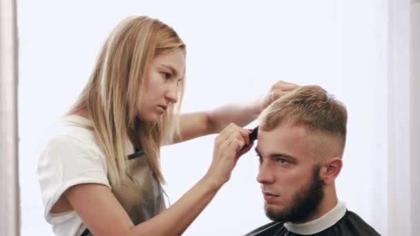 Peluquería haciendo corte de pelo para el cliente usando tijeras en el salón — Vídeos de Stock