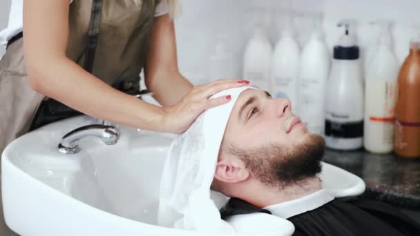 Stylist veegt klanten hoofd met witte handdoek in salon — Stockvideo