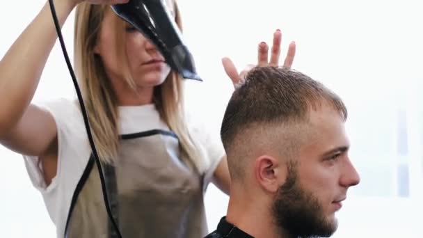 Friseur trocknet Kunden die Haare nach dem Haarschnitt im Salon — Stockvideo