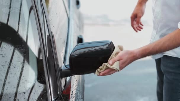 Person washing black car with cloth outside — Stock Video