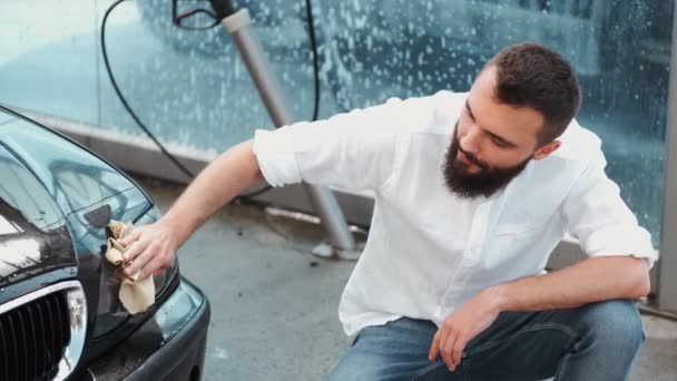 Γενειοφόρος άνδρας πλύσιμο αυτοκινήτων με πανί στο πλυντήριο αυτοκινήτων — Αρχείο Βίντεο