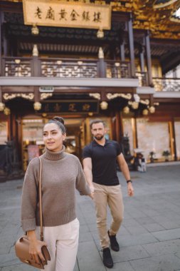 Yeni evli çift Çin 'i ziyaret ederken Şangay' da el ele tutuşuyorlar.